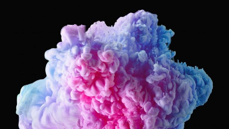 Abstrakte vielfarbige Wolke in einem Glas vor schwarzem Hintergrund. Abstrakte vielfarbige Wolke in einem Glas vor schwarzem Hintergrund.