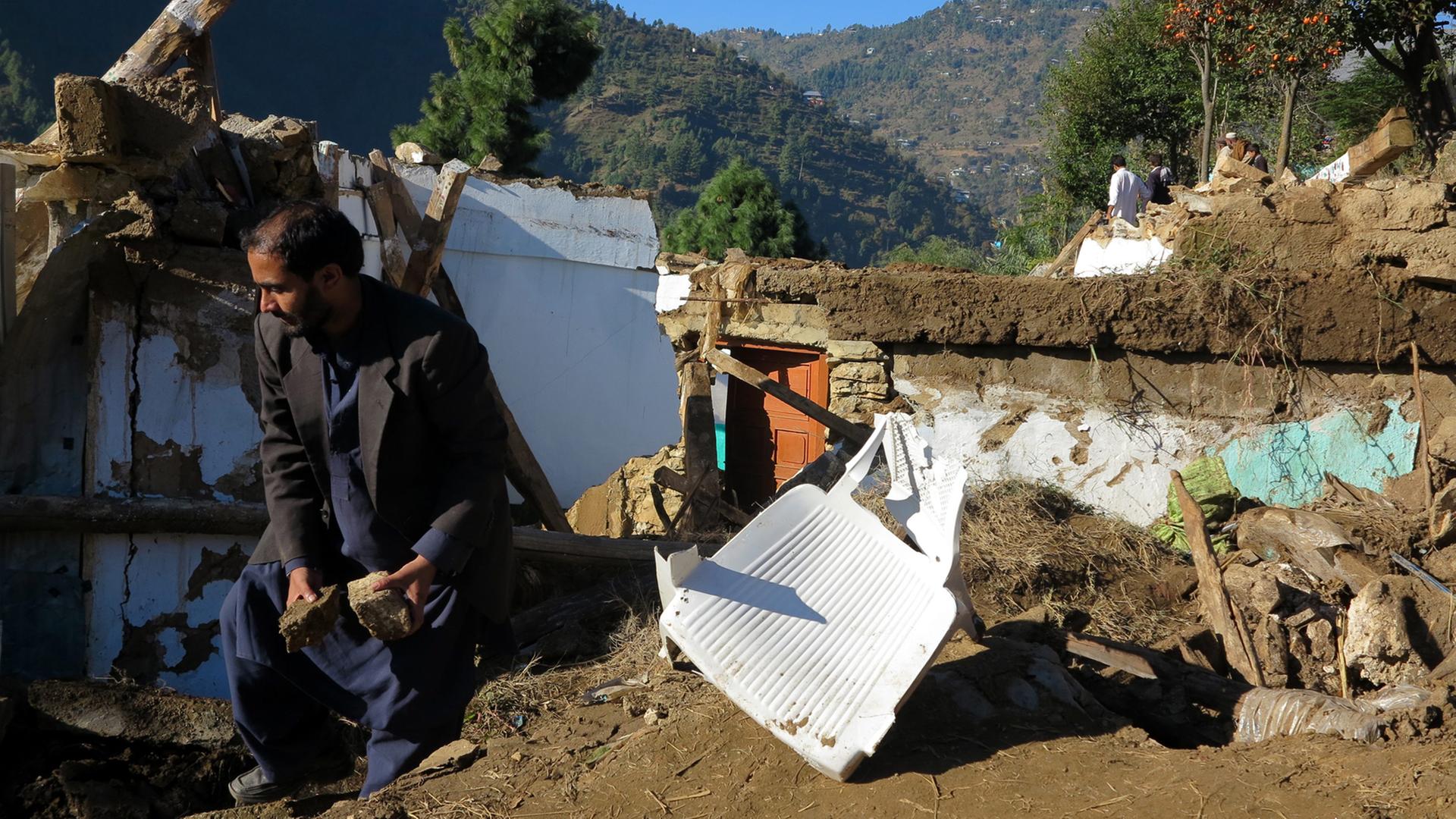 Ein Mann vor seinem kaputten Haus nach dem Erdbeben in der Shangla Region in Pakistan.