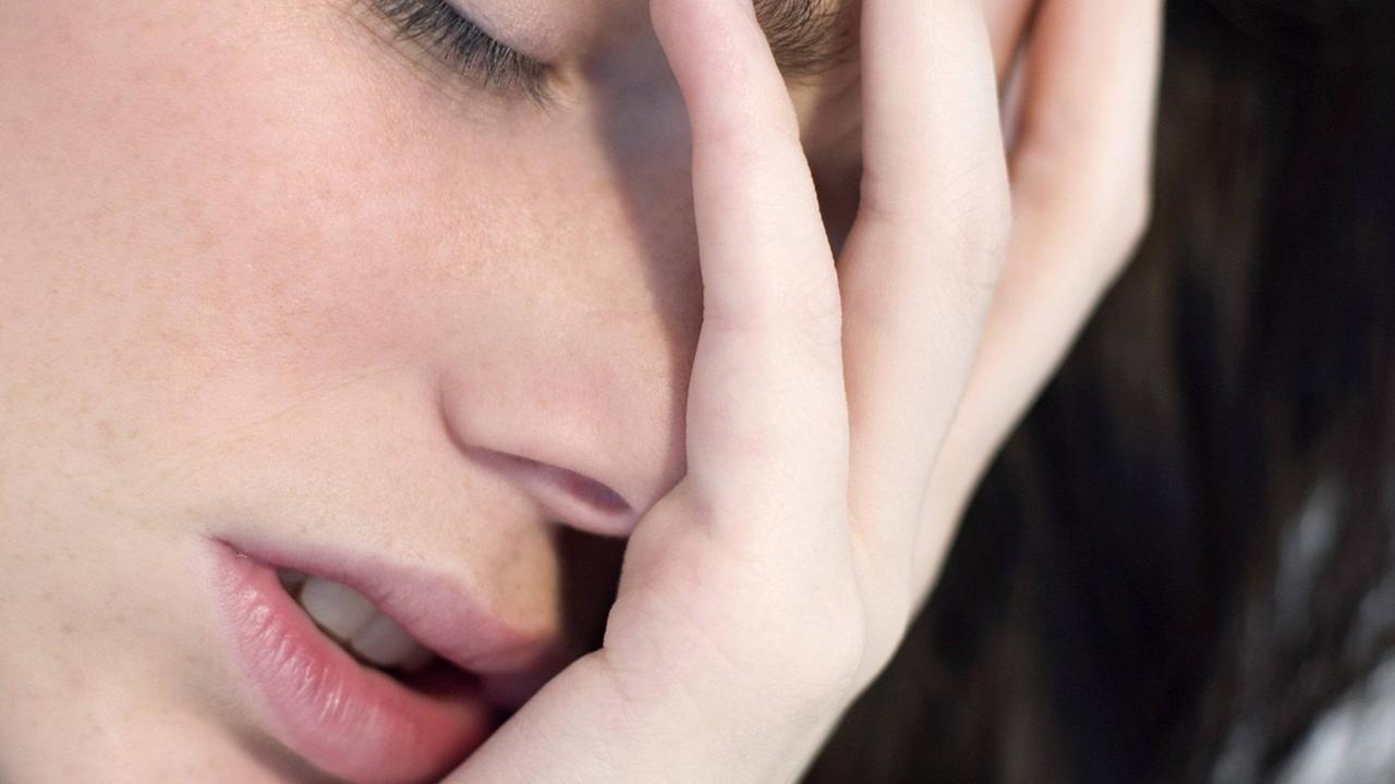 Eine Frau hält den Kopf in den Händen. Eine Frau hält den Kopf in den Händen.