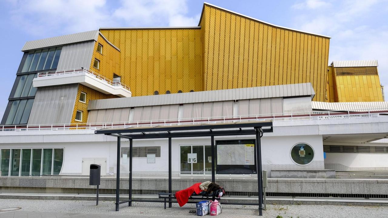 Ein obdachloser Mensch schläft im Juli einem Wartehaeuschen der BVG vor dem Kammermusiksaal im Berliner Tiergartenviertel. Ein obdachloser Mensch schläft im Juli einem Wartehaeuschen der BVG vor dem Kammermusiksaal im Berliner Tiergartenviertel.