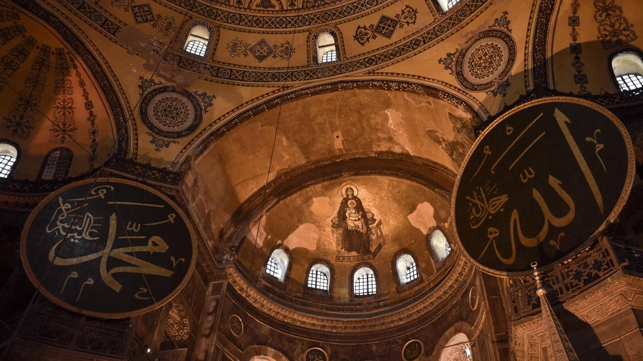In der Hagia Sophia hängen islamische Gebetstafeln in arabischer Schrift neben christlichen Mosaiken - wie hier Maria und Jesus In der Hagia Sophia hängen islamische Gebetstafeln in arabischer Schrift neben christlichen Mosaiken - wie hier Maria und Jesus