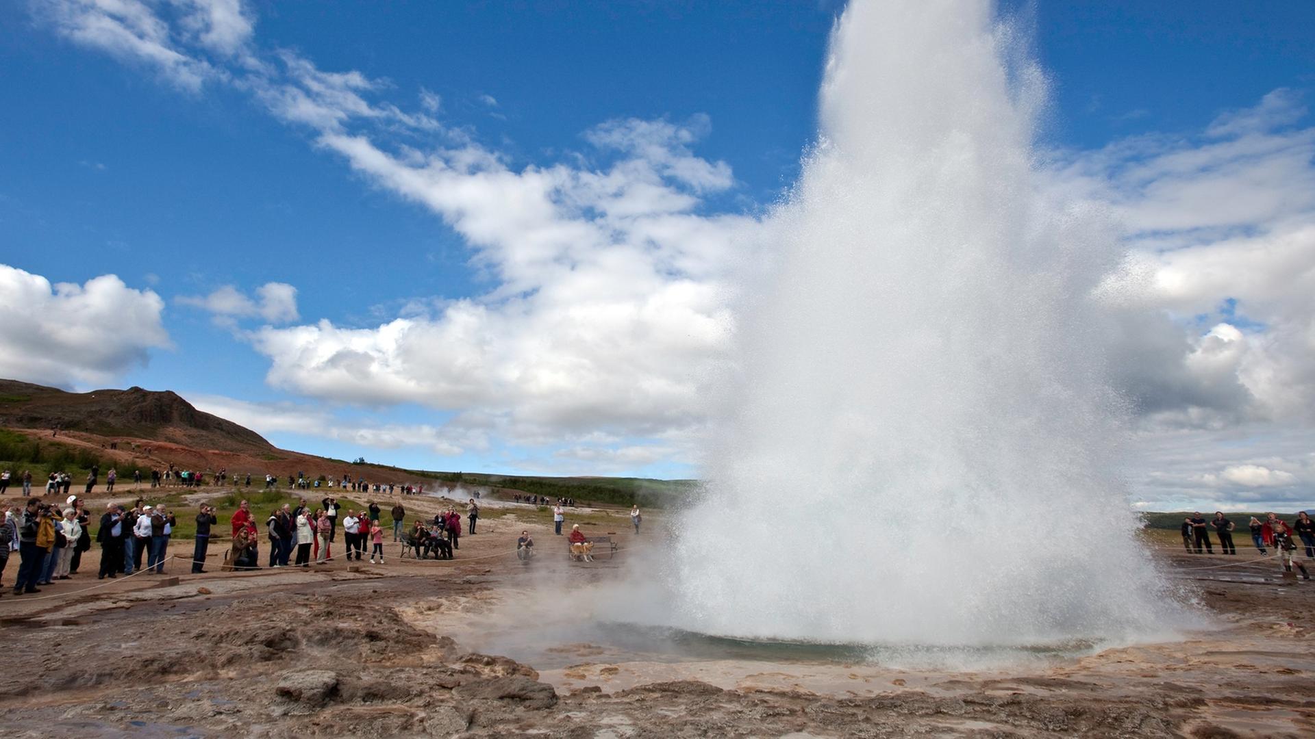 Touristen bestaunen den Geysir Strokkur auf Island. Touristen bestaunen den Geysir Strokkur auf Island.
