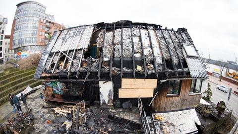Verbrannte Trümmer liegen vor dem Gebäude des Golden Pudel Club in Hamburg