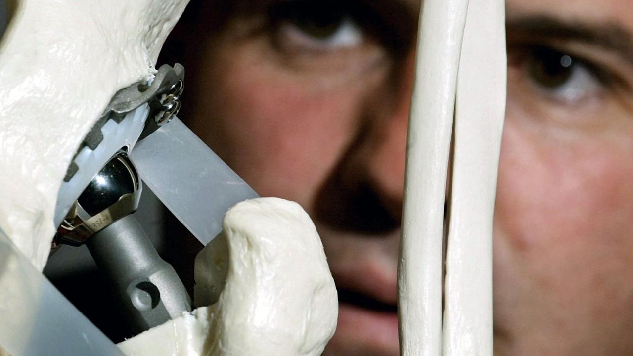 Ein Besucher betrachtet ein Hüftgelenk aus Titan in einer Ausstellung in Hamburg. Ein Besucher betrachtet ein Hüftgelenk aus Titan in einer Ausstellung in Hamburg.