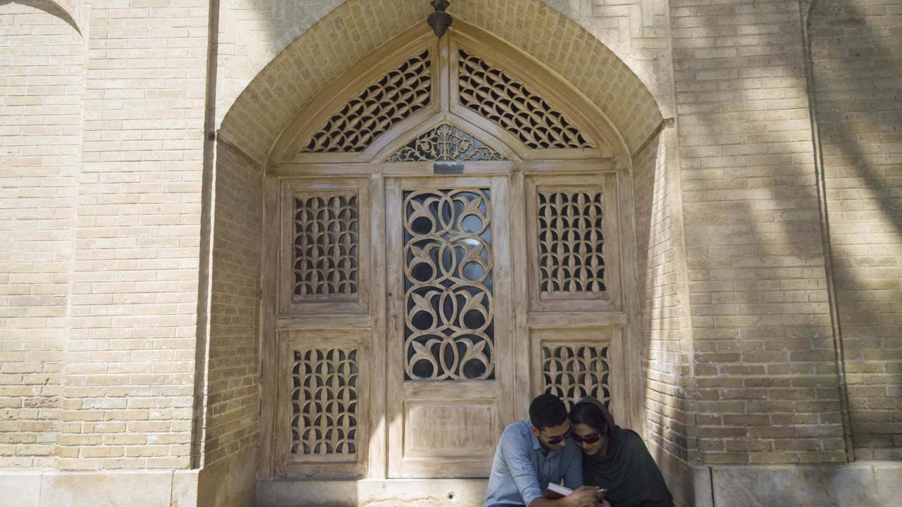 Ein Pärchen liest am Grab des Dichters Hafez in einem Buch