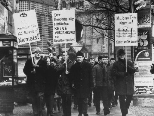 Demonstranten mit Schildern in der Hand protestieren am 6. Februar 1965 in Berlin gegen eine Verjährung von Mord und Völkermord
