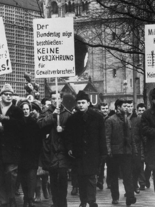 Demonstranten mit Schildern in der Hand protestieren am 6. Februar 1965 in Berlin gegen eine Verjährung von Mord und Völkermord
