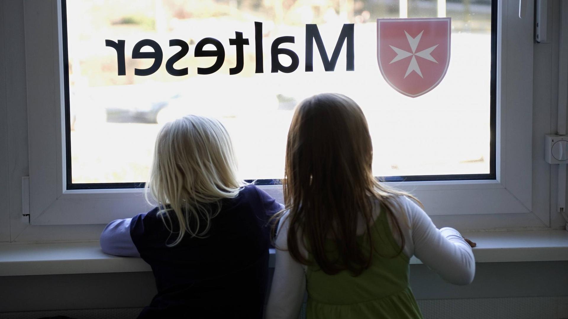 2 Kinder gucken aus einem Fenster. 2 Kinder gucken aus einem Fenster.