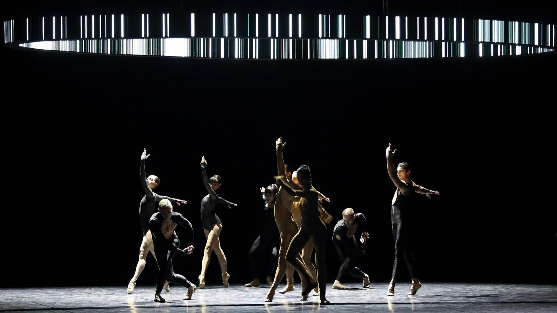 Mehrere Ballett-Tänzerinnen und Tänzer unter einem Lichtkreis Mehrere Ballett-Tänzerinnen und Tänzer unter einem Lichtkreis