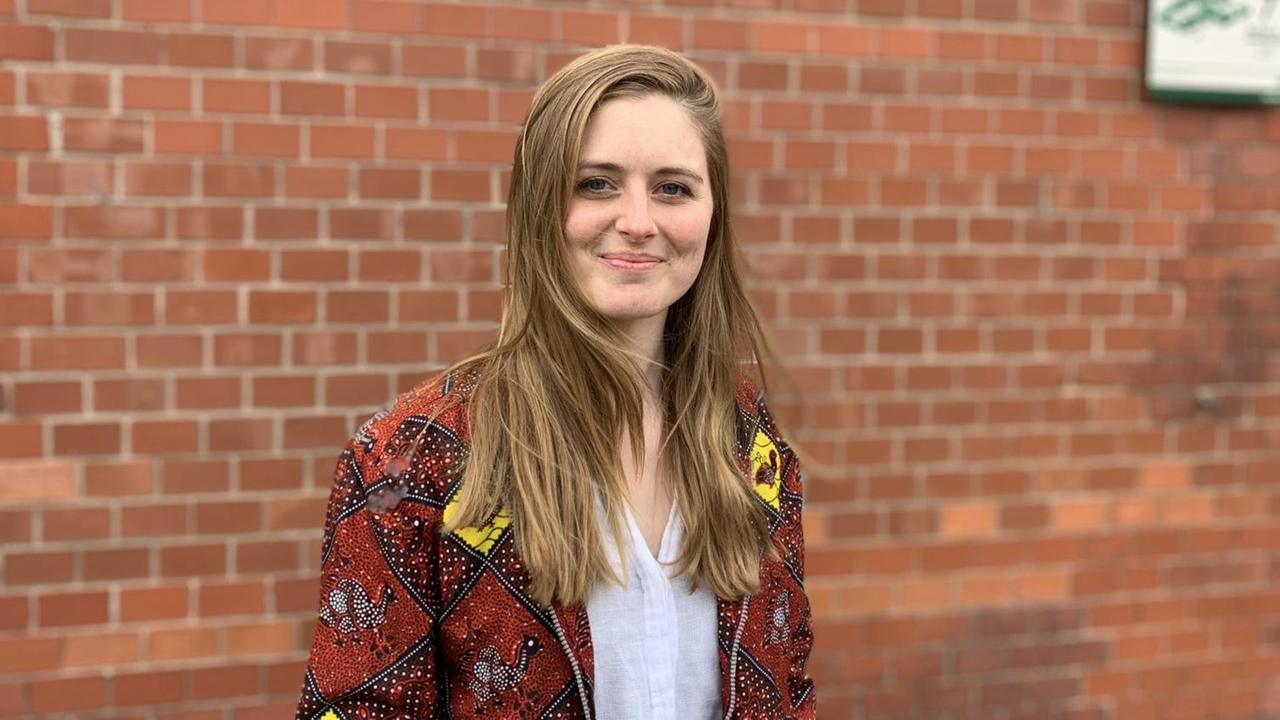 Caroline Weimann steht vor einer Backsteinmauer, sie trägt eine bunt gemusterte Jacke. Caroline Weimann steht vor einer Backsteinmauer, sie trägt eine bunt gemusterte Jacke.