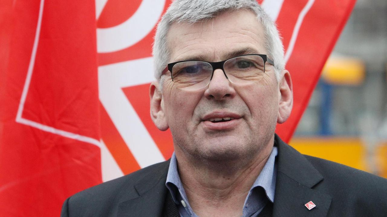 IG-Metall-Chef Jörg Hofmann vor einer herunterhängenden Gewerkschaftsfahne. IG-Metall-Chef Jörg Hofmann vor einer herunterhängenden Gewerkschaftsfahne.