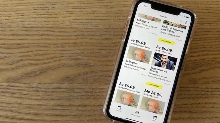 Ein Smartphone liegt auf einem Holztisch, die App PARTi ist geöffnet. Ein Smartphone liegt auf einem Holztisch, die App PARTi ist geöffnet.