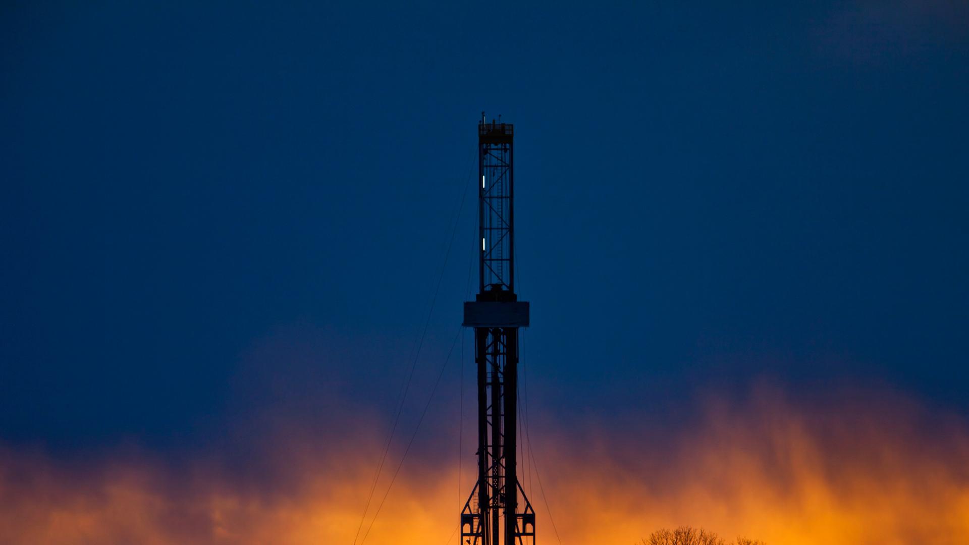 Ein Fracking-Bohrturm in der Abenddämmerung. Ein Fracking-Bohrturm in der Abenddämmerung.