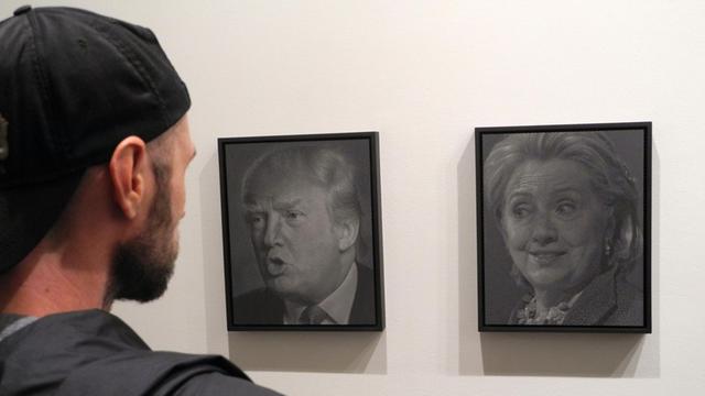 Besucher betrachten am 13.10.2016 die Porträts "Trump (Clinton)" (l) und "Clinton (Trump)" (r) des Künstlers Alfred Steiner in der Ausstellung «Why I Want to Fuck Donald Trump» in der Joshua Liner Gallery in New York (USA).