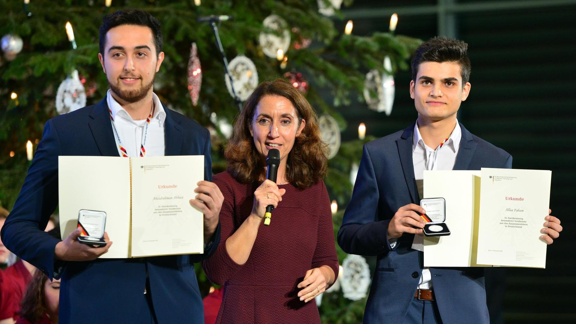 Abdul Abbasi (l) aus Göttingen und Allaa Faham (r) aus Hamburg bekommen am 19.12.2016 in Berlin von Staatsministerin Aydan Özoguz (SPD) eine Integrationsmedaille anlässlich des Internationalen Tags der Migranten 2016. F Abdul Abbasi (l) aus Göttingen und Allaa Faham (r) aus Hamburg bekommen am 19.12.2016 in Berlin von Staatsministerin Aydan Özoguz (SPD) eine Integrationsmedaille anlässlich des Internationalen Tags der Migranten 2016. F