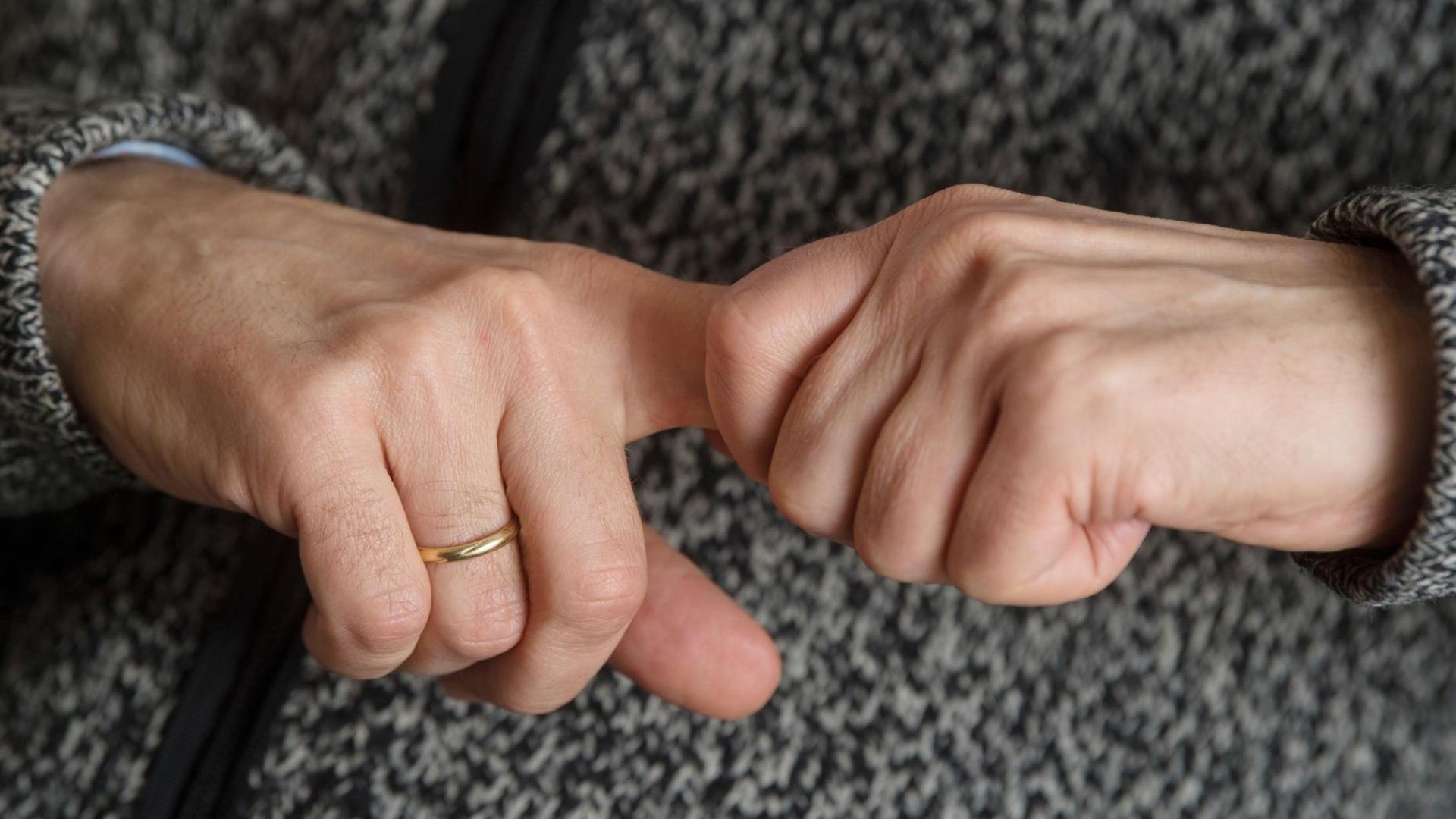 Ein Mann versucht, seine Fingergelenke knacken zu lassen (gestellte Szene). Ein Mann versucht, seine Fingergelenke knacken zu lassen (gestellte Szene).