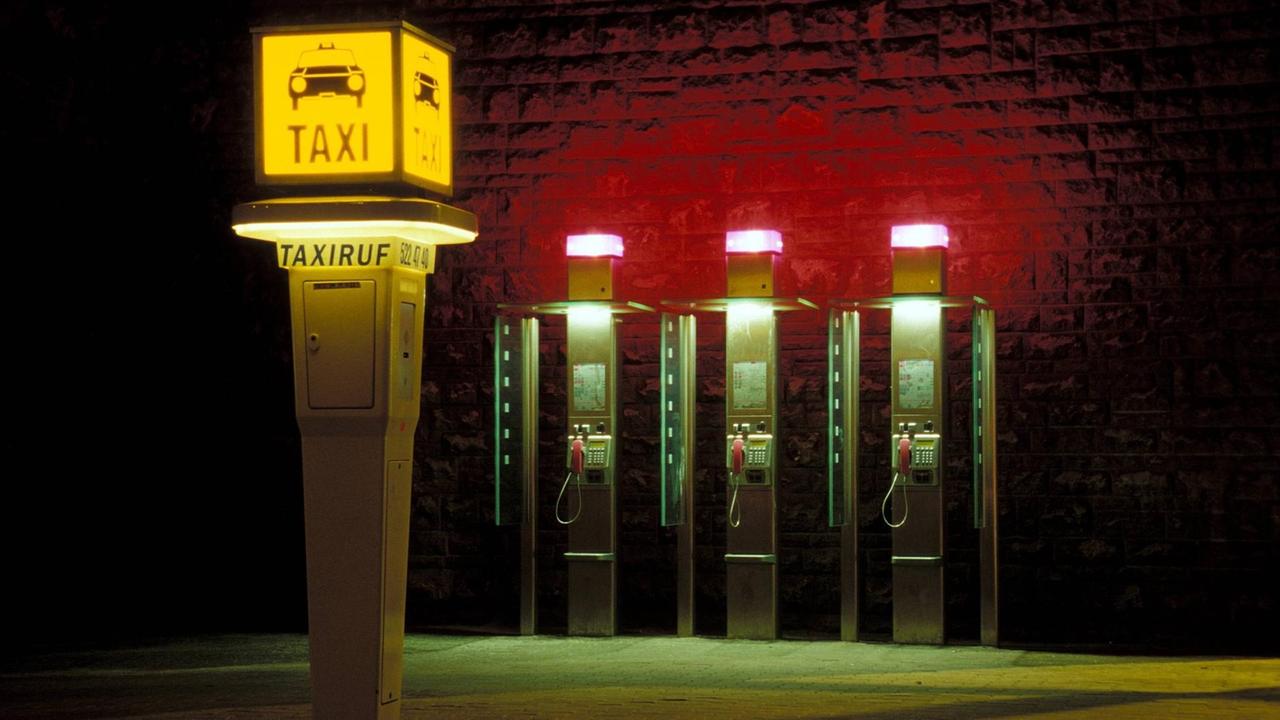 Eine Taxirufsäule und drei Telefonzellen bei Nacht. Eine Taxirufsäule und drei Telefonzellen bei Nacht.