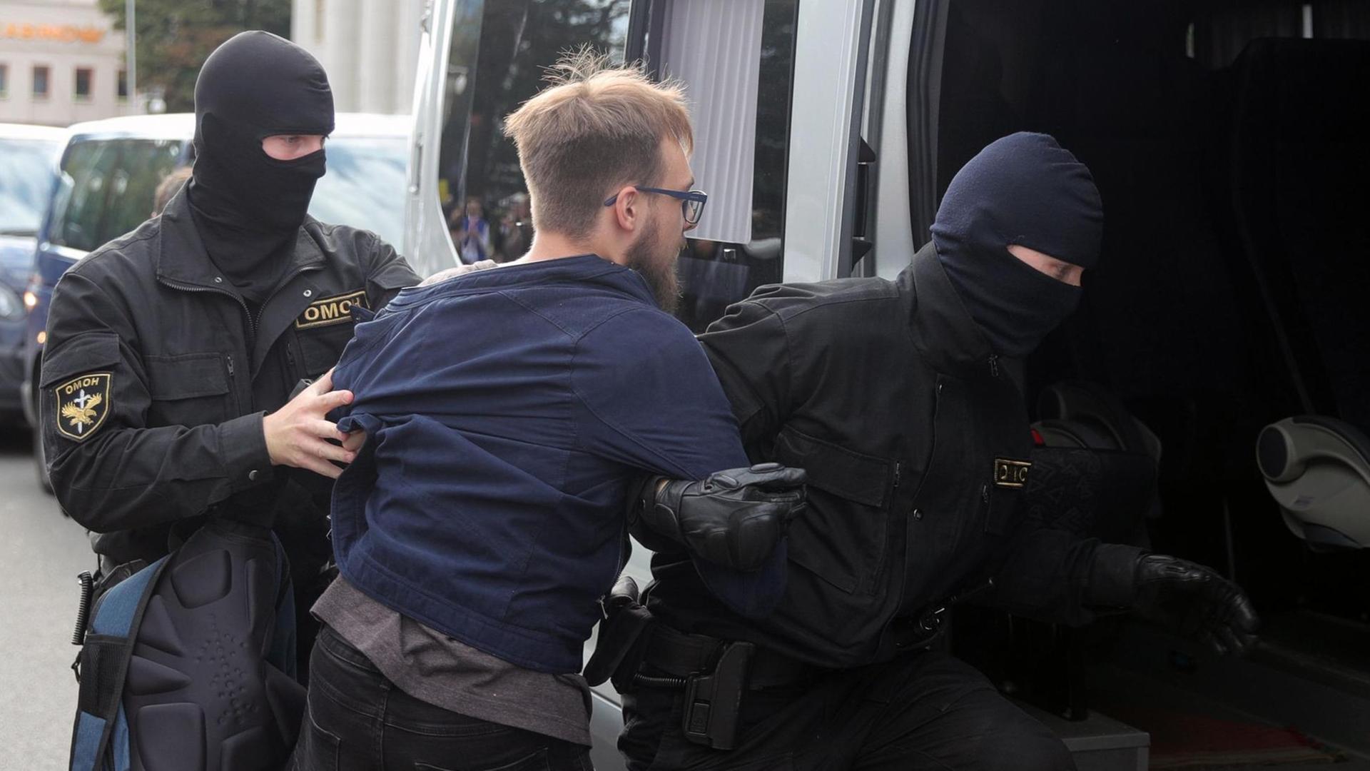 Polizeikräfte nehmen bei Protesten in Minsk einen Studenten fest und schieben ihn in einen Transporter. Polizeikräfte nehmen bei Protesten in Minsk einen Studenten fest und schieben ihn in einen Transporter.