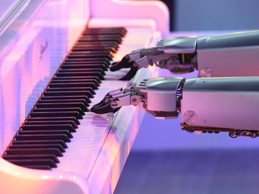 Zwei Roboterarme spielen Klavier.
