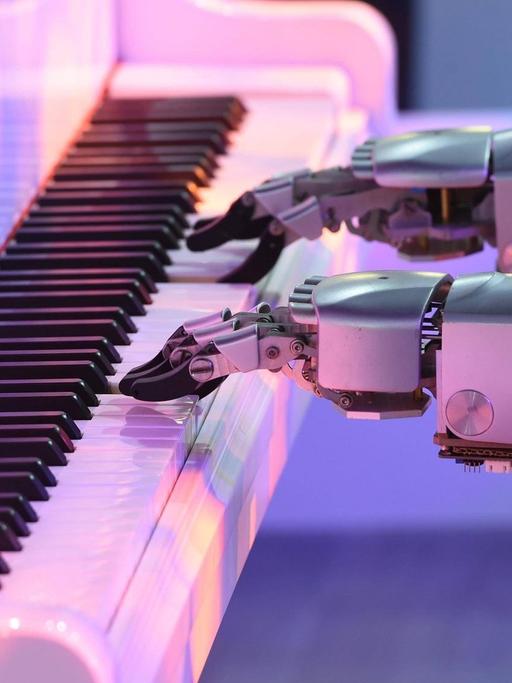 Zwei Roboterarme spielen Klavier.