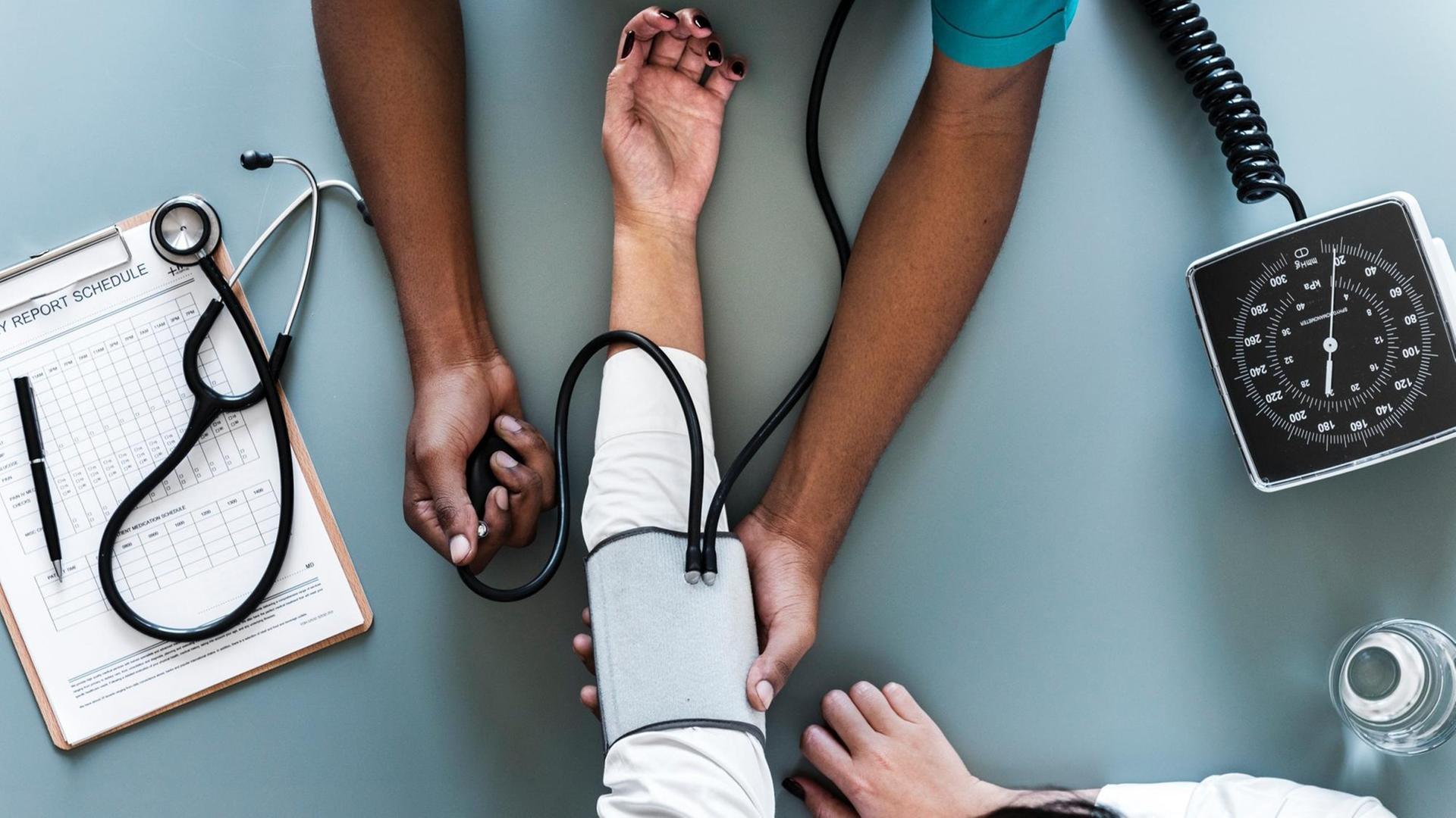 An einem Unterarm wird der Puls gemessen, drumherum liegt weiteres medizinisches Equipment An einem Unterarm wird der Puls gemessen, drumherum liegt weiteres medizinisches Equipment