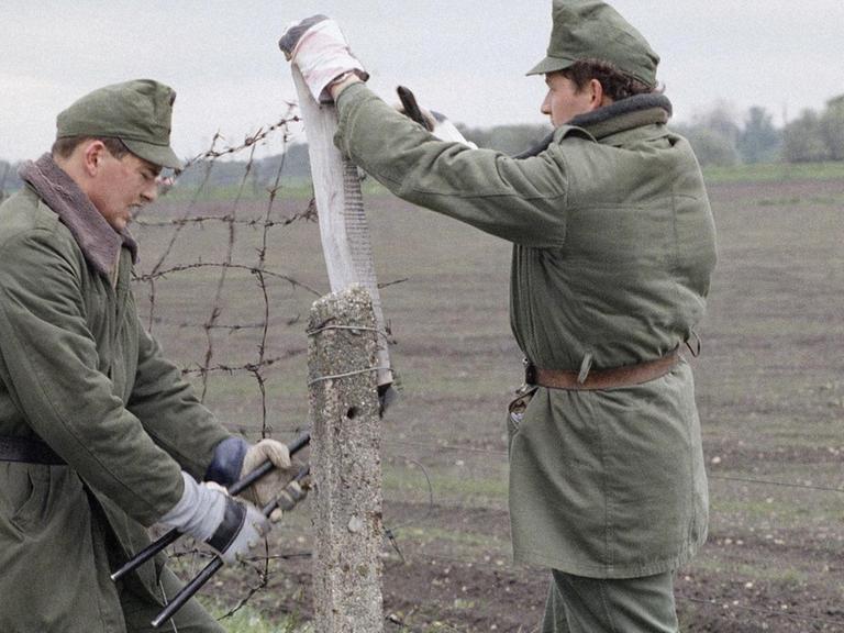 Ungarische Grenzbeamte schneiden im Mai 1989 an der Grenze zu Österreich ein Loch in den "Eisernen Vorhang"