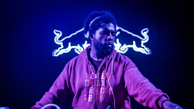 Zu sehen ist Hip-Hop Künstler Questlove vor einem Logeo der Red Bull Music Academy. Zu sehen ist Hip-Hop Künstler Questlove vor einem Logeo der Red Bull Music Academy.