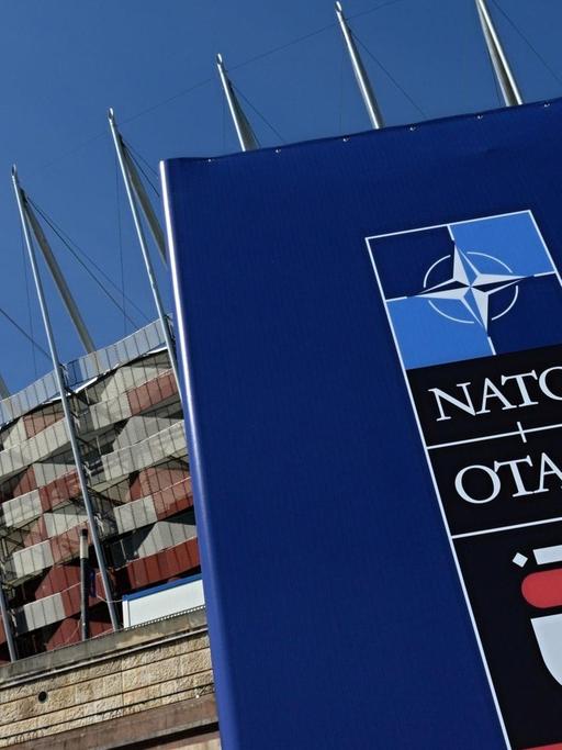 Ein Schild mit der Aufschrift Nato vor dem Stadion in Polens Hauptstadt Warschau