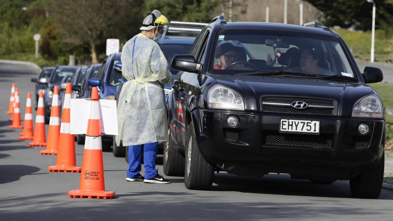 Medizinisches Personal in Neuseeland führt Corona-Tests bei Menschen in Autos durch. Medizinisches Personal in Neuseeland führt Corona-Tests bei Menschen in Autos durch.