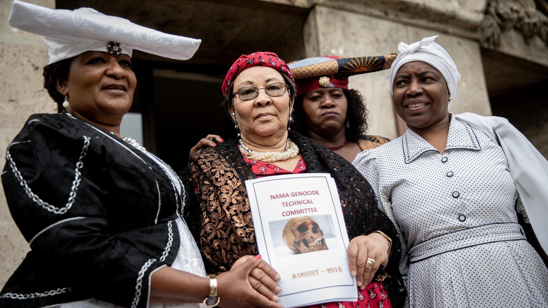 27.08.2018, Berlin: Eine Delegation von Ovaherero und Nama aus Namibia, Esther Utjiua Muinjangue (l), Vorsitzende der Ovaherero Genocide Foundation in Namibia, Ida Hoffmann (2.v.l), Parlamentsabgeordnete und Vorsitzende des Nama Genocide Technical Committee in Namibia und weiteren Delegationsmitgliedern stehen nach einem Treffen und einer Pressekonferenz mit Justizsenator Behrendt (nicht im Bild) vor der Senatsverwaltung für Justiz, Verbraucherschutz und Antidiskriminierung. 27.08.2018, Berlin: Eine Delegation von Ovaherero und Nama aus Namibia, Esther Utjiua Muinjangue (l), Vorsitzende der Ovaherero Genocide Foundation in Namibia, Ida Hoffmann (2.v.l), Parlamentsabgeordnete und Vorsitzende des Nama Genocide Technical Committee in Namibia und weiteren Delegationsmitgliedern stehen nach einem Treffen und einer Pressekonferenz mit Justizsenator Behrendt (nicht im Bild) vor der Senatsverwaltung für Justiz, Verbraucherschutz und Antidiskriminierung.