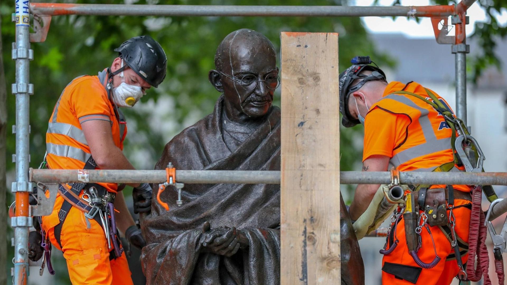 Arbeiter bauen vor einer Demonstration in London einen Schutz um die Statue des Friedensaktivisten Mahatma Gandhi. Arbeiter bauen vor einer Demonstration in London einen Schutz um die Statue des Friedensaktivisten Mahatma Gandhi.