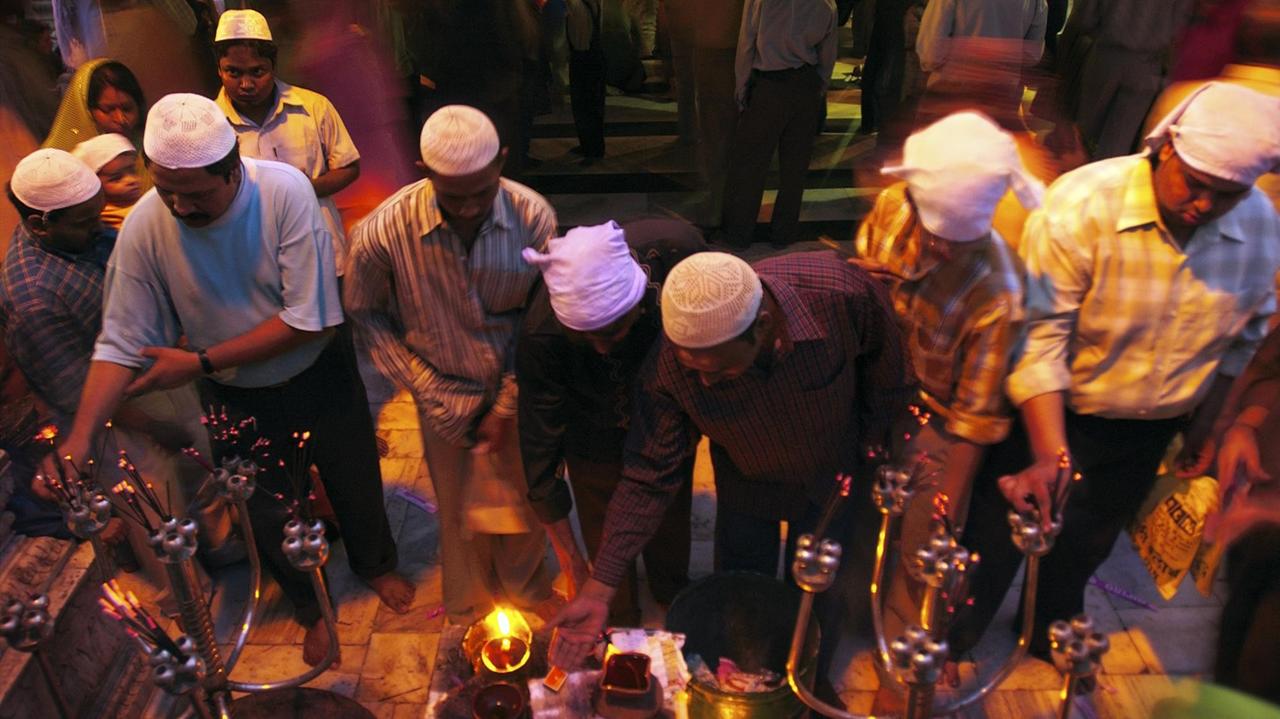 Indische Gläubige entzünden Kerzen in einem Sufi-Schrein. Indische Gläubige entzünden Kerzen in einem Sufi-Schrein.