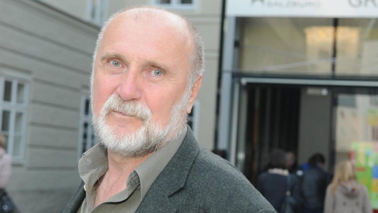 Der bosnische Autor Dževad Karahasan blickt mit leicht geneigtem Kopf in die Kamera. Der bosnische Autor Dževad Karahasan blickt mit leicht geneigtem Kopf in die Kamera.
