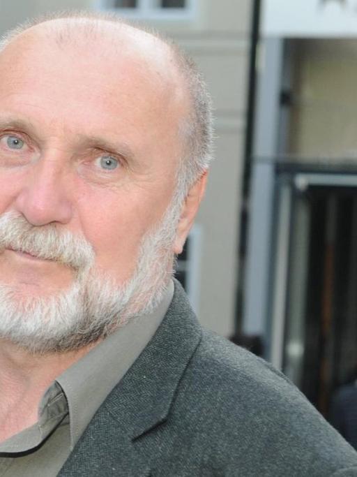 Der bosnische Autor Dževad Karahasan blickt mit leicht geneigtem Kopf in die Kamera.