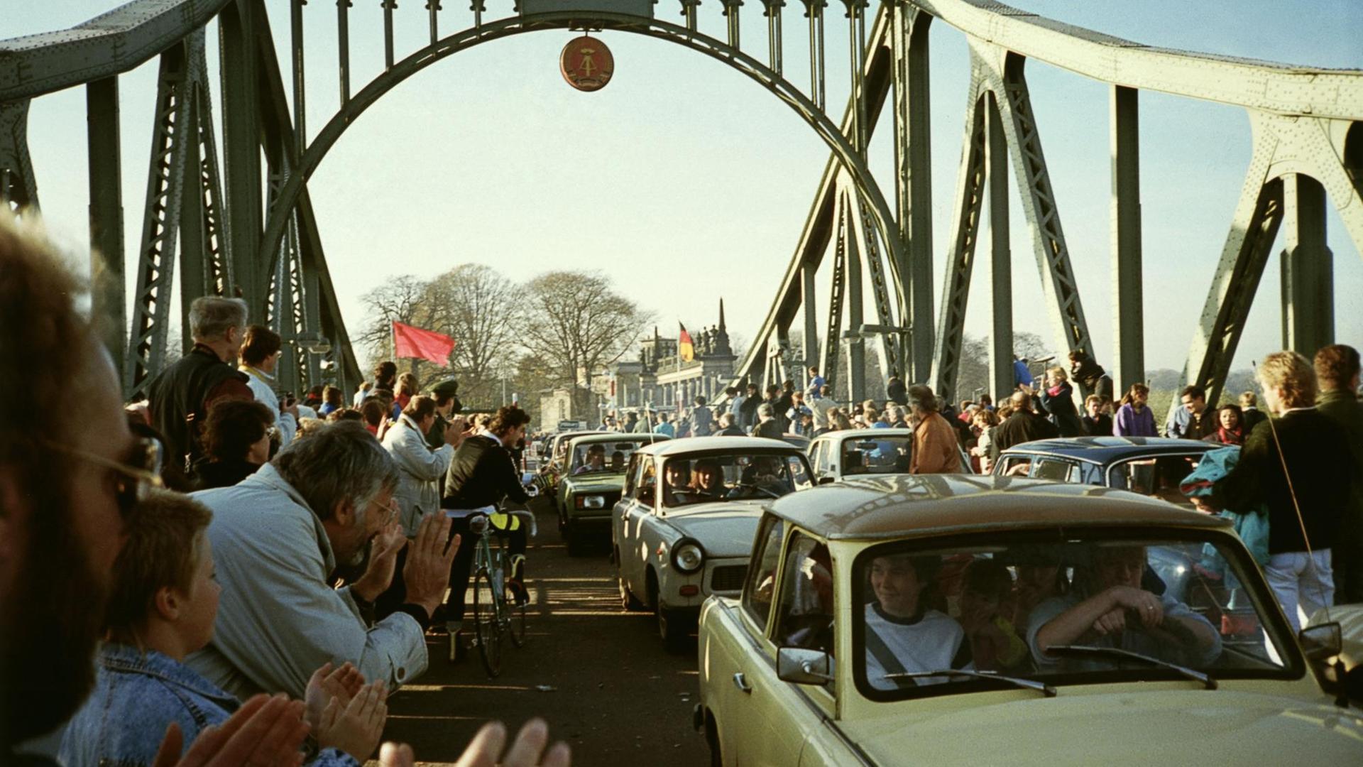 Viele Menschen klatschen und jubel während Trabbis über die Brücke fahren. Viele Menschen klatschen und jubel während Trabbis über die Brücke fahren.