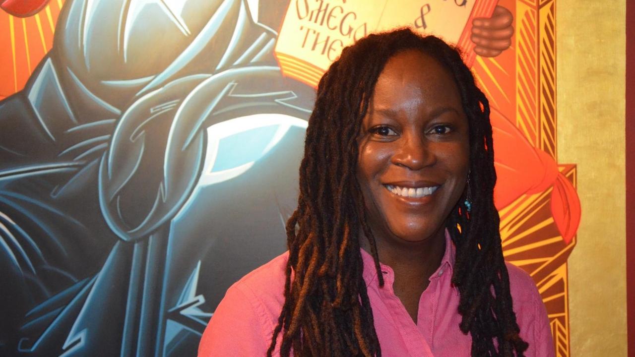 Eine lächelnde Frau mit langen Dreadlocks im Altarraum der John Coltrane Church San Francisco. Das Bild zeigt Wanika Stephens-King, sie ist seit 2010 Pastorin der Kirche Eine lächelnde Frau mit langen Dreadlocks im Altarraum der John Coltrane Church San Francisco. Das Bild zeigt Wanika Stephens-King, sie ist seit 2010 Pastorin der Kirche