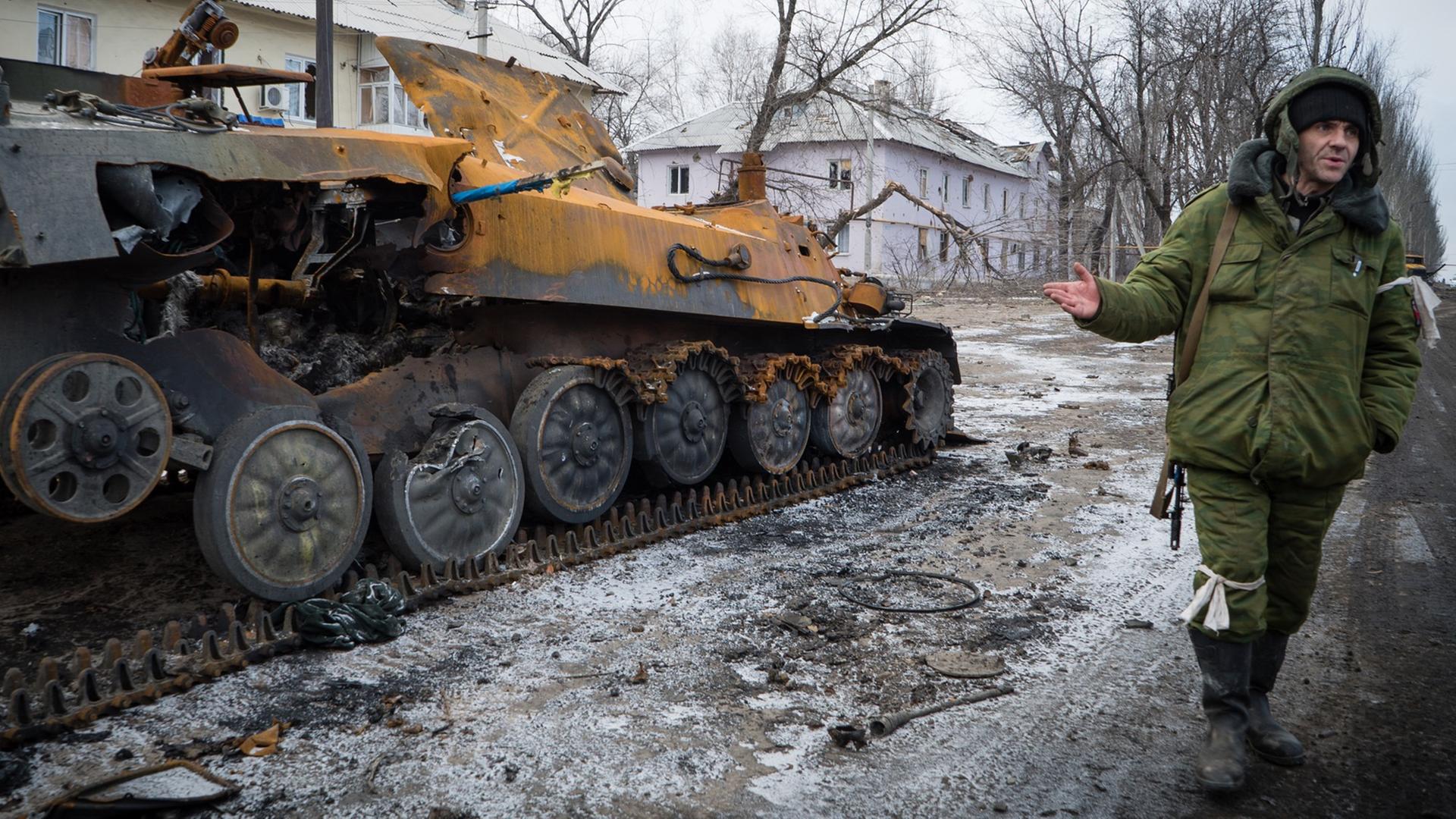 Ein prorussischer Rebell neben einem zerstörten Panzerfahrzeug in der Stadt Vuglegirsk, Region Donetzk. Ein prorussischer Rebell neben einem zerstörten Panzerfahrzeug in der Stadt Vuglegirsk, Region Donetzk.