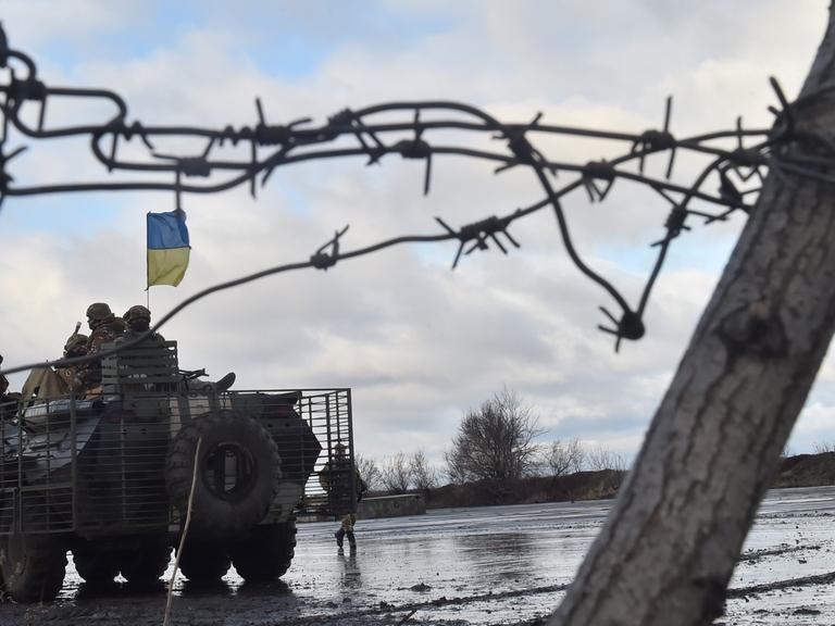 Ukrainische Soldaten hinter einem Stacheldrahtzaun