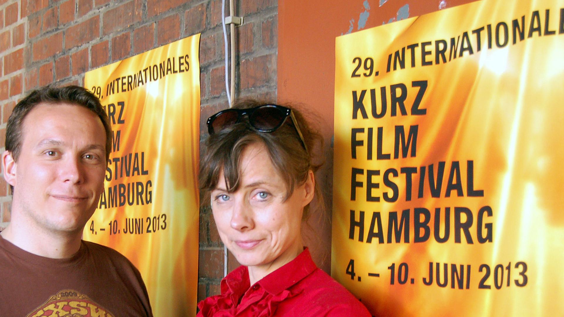 Die Festivalleiter Birgit Glombitza und Sven Schwarz stehen am 08.06.2013 im Zeise-Kino in Hamburg vor einem Plakat des Internationalen Kurzfilmfestivals Hamburg.