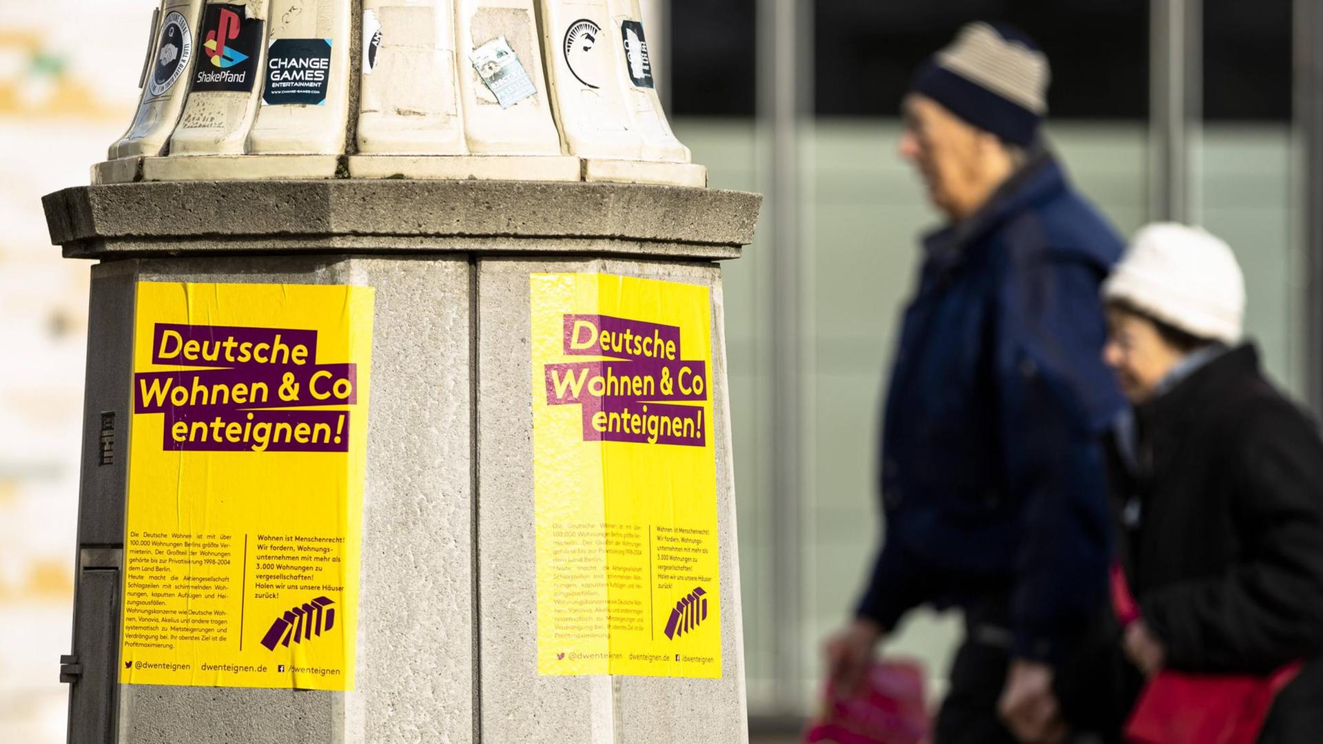 Protestplakate gegen Deutsche Wohnen und Passanten in der Karl-Marx-Allee in Berlin. Protestplakate gegen Deutsche Wohnen und Passanten in der Karl-Marx-Allee in Berlin.