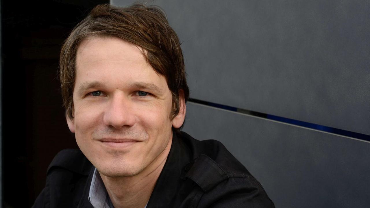 Fridolin Schley vor einer Wand. Er blickt direkt in die Kamera. Fridolin Schley vor einer Wand. Er blickt direkt in die Kamera.
