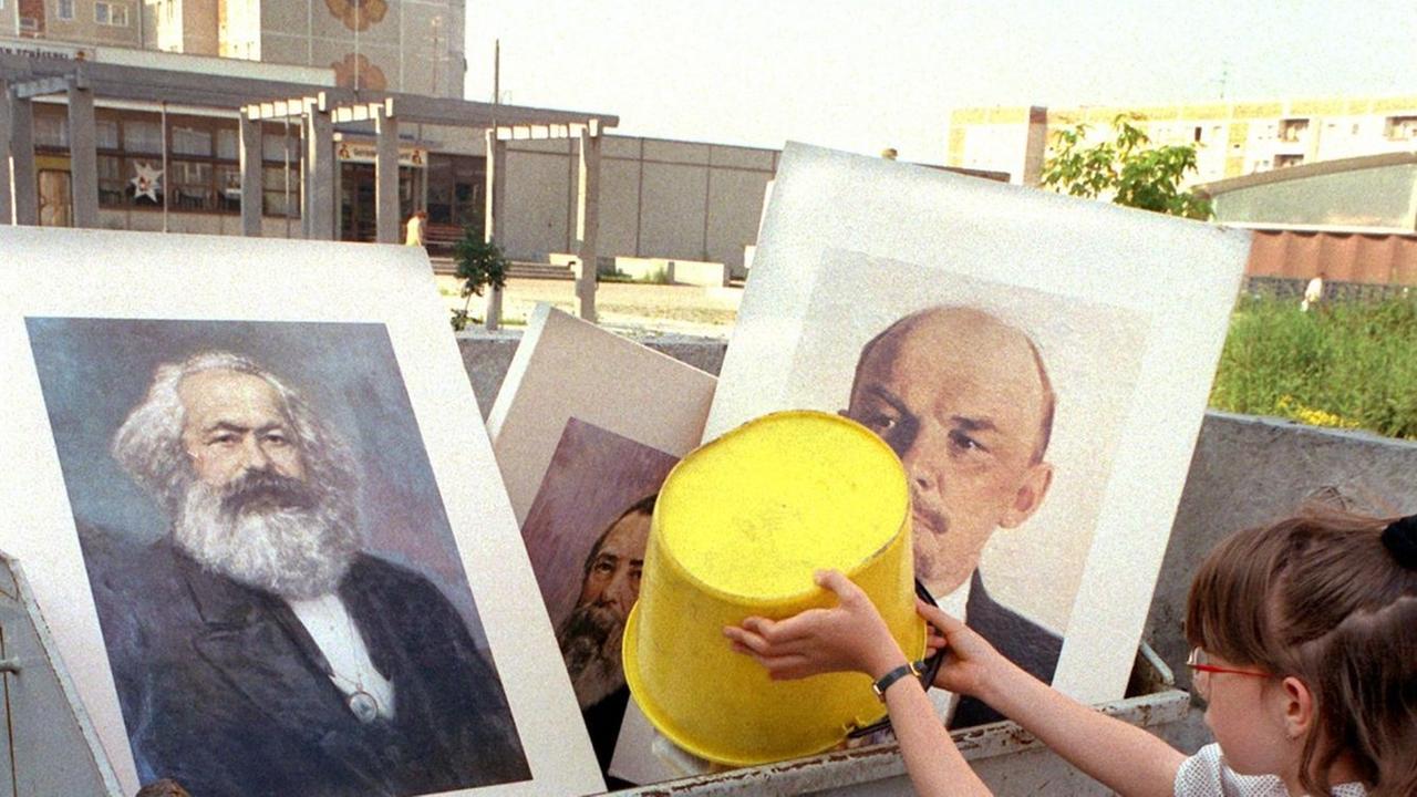 Ein Mädchen schüttet Abfall in einen Müllcontainer, in dem bereits die Bilder von Marx und Lenin liegen. Aufgenommen im Juli 1991 bei einer Aufräumaktion an einer Schule im Berliner Stadtbezirk Hellershof. Ein Mädchen schüttet Abfall in einen Müllcontainer, in dem bereits die Bilder von Marx und Lenin liegen. Aufgenommen im Juli 1991 bei einer Aufräumaktion an einer Schule im Berliner Stadtbezirk Hellershof.