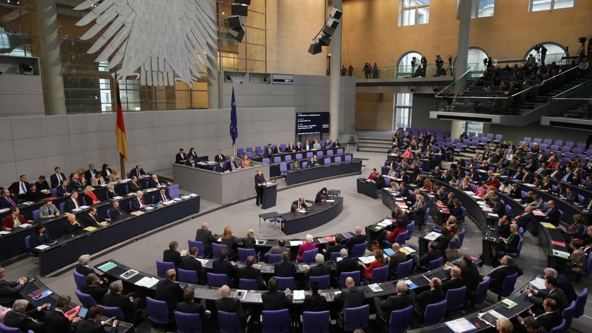 Der Blick auf das gut besetzte Plenum des Bundestages, am Rednerpult Kanzlerin Angela Merkel. Der Blick auf das gut besetzte Plenum des Bundestages, am Rednerpult Kanzlerin Angela Merkel.