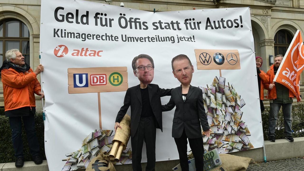 Zwei Aktivisten von attac stehen verkleidet als Bundesverkehrsminister Scheuer (l) und als VW-Vorstandsvorsitzender Diess vor dem Bundesverkehrsministerium. Zwei Aktivisten von attac stehen verkleidet als Bundesverkehrsminister Scheuer (l) und als VW-Vorstandsvorsitzender Diess vor dem Bundesverkehrsministerium.