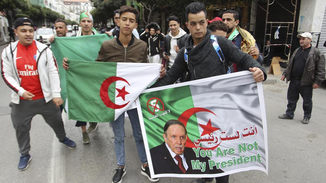 Jugendliche halten ein Poster mit einem Abbild von Präsident Bouteflika und der Aufschrift "Du bist nicht mein Präsident"