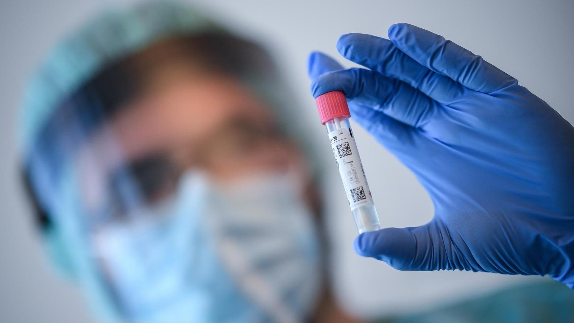 Ein Arzt nimmt in der Corona-Teststelle am Flughafen Schönefeld einen Abstrich für einen Coronavirus-Test. Ein Arzt nimmt in der Corona-Teststelle am Flughafen Schönefeld einen Abstrich für einen Coronavirus-Test.