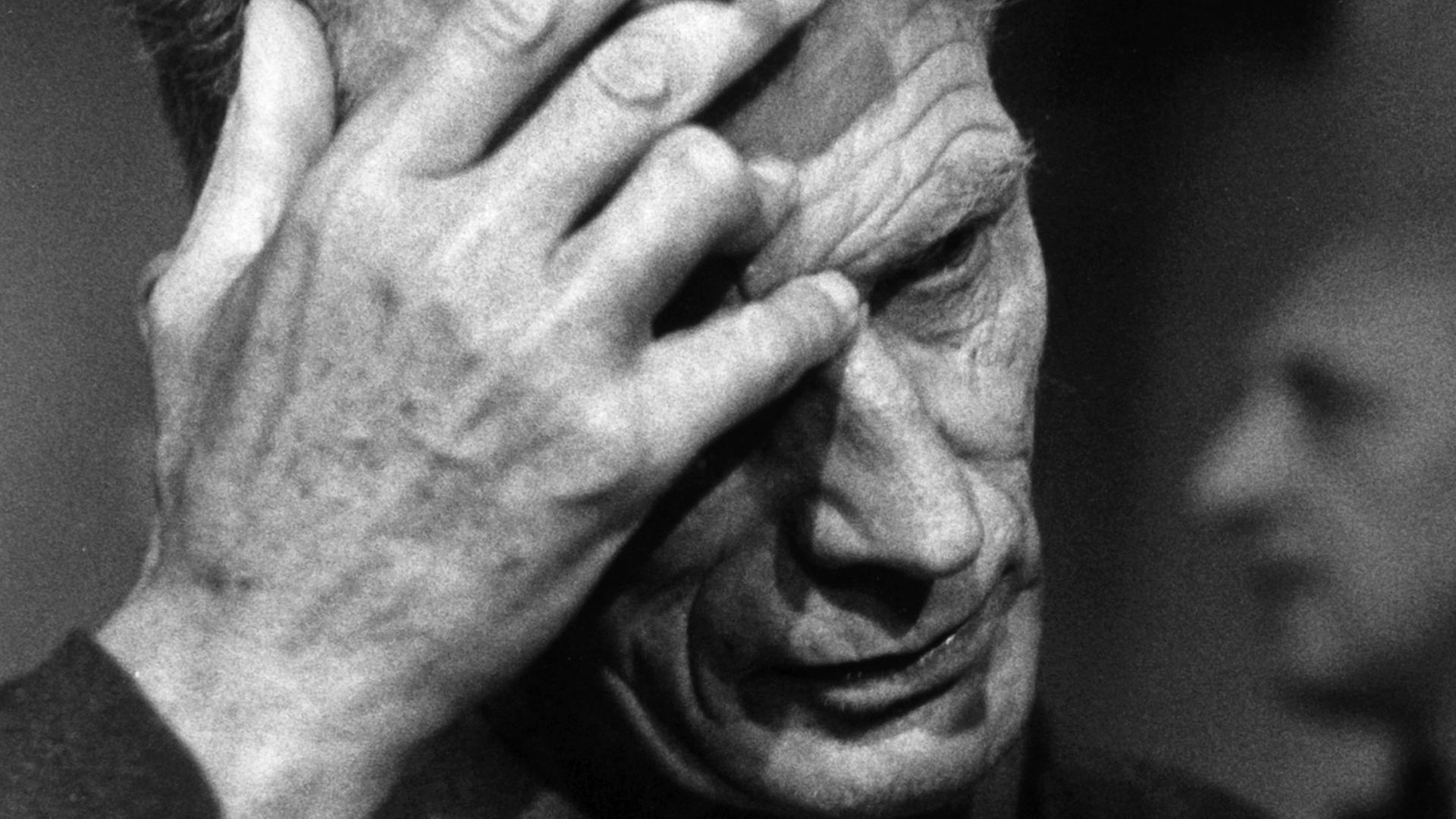 Der Dramatiker Samuel Beckett greift sich am 23.09.1967 auf der Studiobühne des Berliner Schiller-Theaters bei den Theaterproben zu seinem Stück "Endspiel" an die Stirn. In seiner Hand hält er eine Zigarette. Der Dramatiker Samuel Beckett greift sich am 23.09.1967 auf der Studiobühne des Berliner Schiller-Theaters bei den Theaterproben zu seinem Stück "Endspiel" an die Stirn. In seiner Hand hält er eine Zigarette.