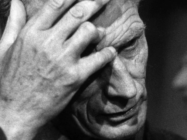 Der Dramatiker Samuel Beckett greift sich am 23.09.1967 auf der Studiobühne des Berliner Schiller-Theaters bei den Theaterproben zu seinem Stück "Endspiel" an die Stirn. In seiner Hand hält er eine Zigarette.
