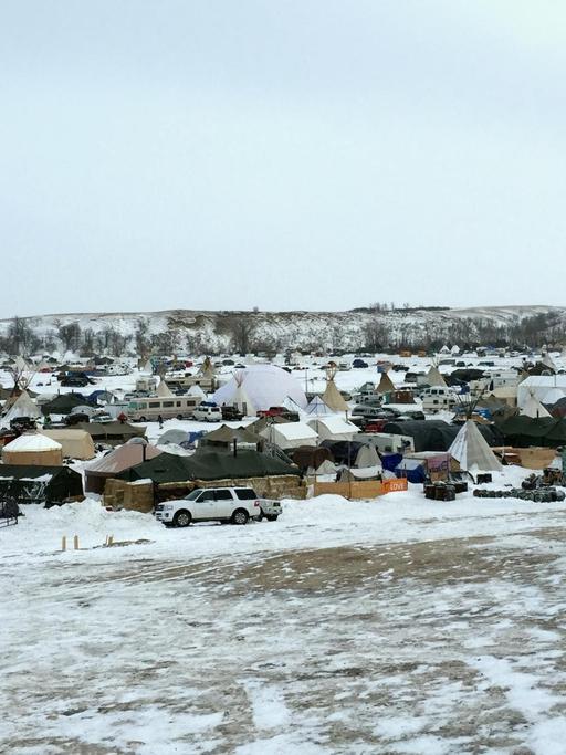 Von einem Hügel sieht man hunderte Zelte im Schnee von Demonstranten gegen die Öl-Pipeline.