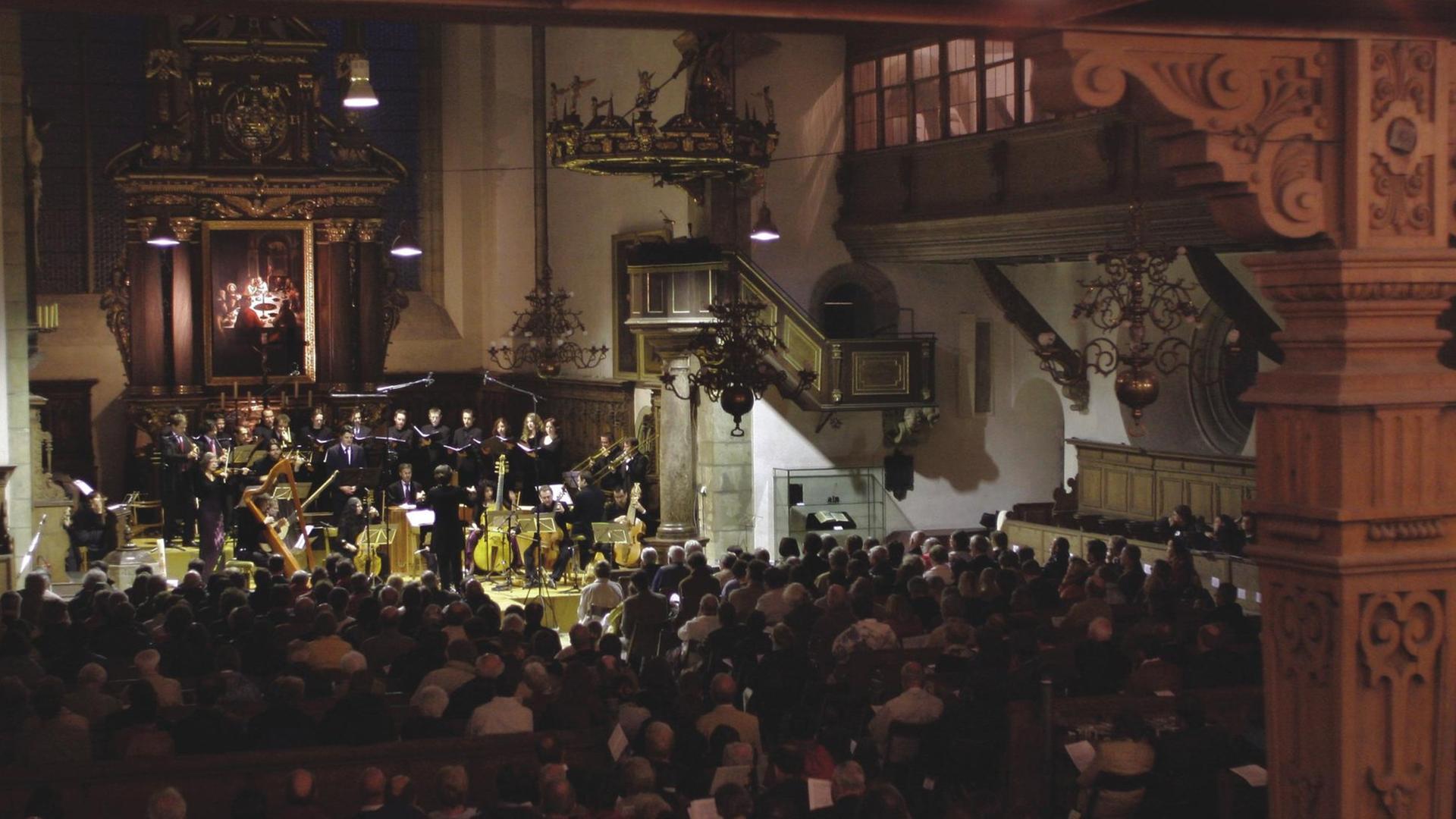 Blick in einen Kirchenraum, in dessen Altarbereich ein Orchester mit historischen Instrumenten spielt. Blick in einen Kirchenraum, in dessen Altarbereich ein Orchester mit historischen Instrumenten spielt.
